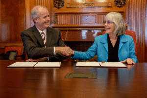 Dr. Alan Sams from TAMU and Susan Seestrom from Los Alamos shake hands after signing the Alliance Partnership MOU